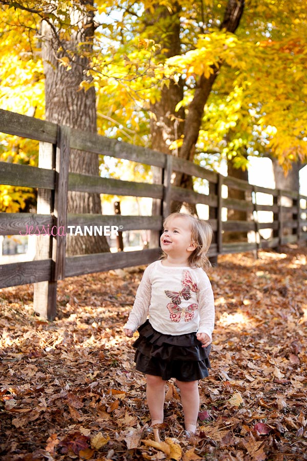 Little girl dancing in the fall leaves